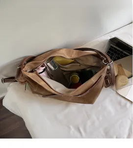 Spacious interior of brown suede tote bag filled with umbrella, water bottle, and daily items