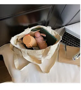 Detailed interior of a beige canvas tote bag showing large capacity and side pockets