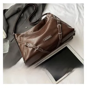 Detailed shot of brown vintage tote bag with contrast stitching and metal buckle accents