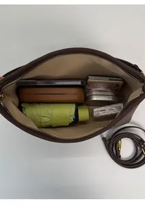 Top view of spacious brown tote bag interior filled with daily essentials for storage