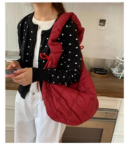 Détail d'un grand sac cabas rouge avec surpiqûres en forme de cœur et texture rembourrée