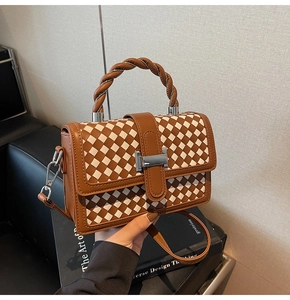 Detail of checkered crossbody bag with twisted handle and silver metallic buckle lock