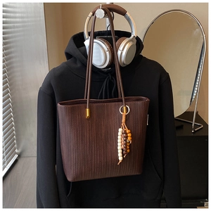 Dettaglio della borsa tote vintage marrone scuro con trama intrecciata e nappa