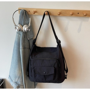 Detail of black waterproof nylon crossbody bag with functional pockets and wide strap