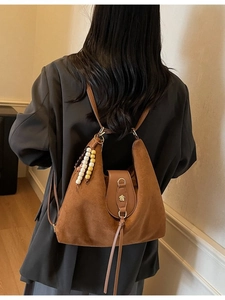 Retro frosted caramel tote bag with colorful beads and fringe in a stylish indoor setting