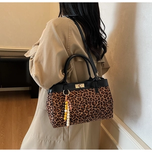 Dettaglio borsa leopardata con chiusura dorata e ciondolo di perline stile boho
