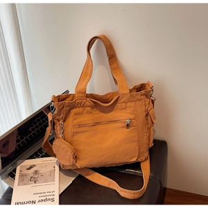 Detail of warm orange canvas tote bag with front zipper pocket and round coin purse