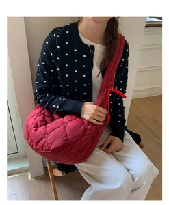 Détail du sac matelassé rouge à motifs cœurs avec une large bandoulière plissée