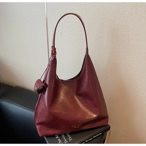 Détail du sac cabas bordeaux avec bandoulière à nœuds tressés et logo sur similicuir