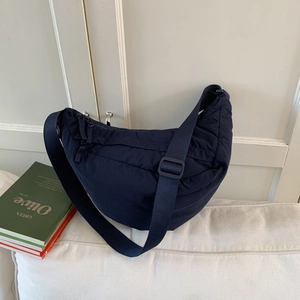 Macro shot of navy blue crescent nylon bag with adjustable strap and textured fabric