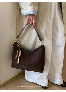 Close-up of vintage dark brown matte leather handbag with colorful beaded tassel detail
