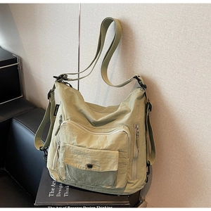 Detailed view of the matcha green nylon crossbody bag featuring multiple zipper pockets