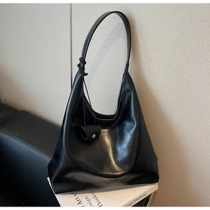 Détail macro du sac hobo noir rétro montrant la texture du cuir synthétique brillant
