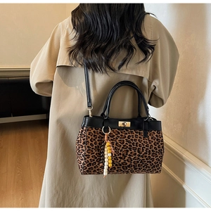 Dettaglio della borsa in pelle scamosciata leopardata con chiusura dorata e perline