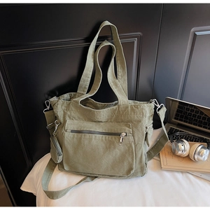 Detail view of army green canvas tote bag with adjustable strap and small round pouch
