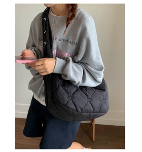 Détail du sac bandoulière matelassé noir avec broderie cœur et large bandoulière