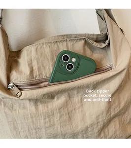 Detail of a khaki tote bag showing the secure back zipper pocket for phone storage