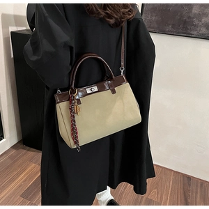 Detail of crossbody bag with silver twist lock and decorative striped silk scarf handle