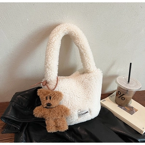 Gros plan détaillé du sac seau en laine d'agneau blanche avec un charmant petit ours brun