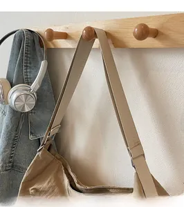 Detail of wide adjustable shoulder strap with silver buckle on minimalist crossbody bag