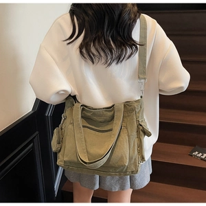 Detail view of army green canvas tote bag with functional pockets and wide shoulder strap
