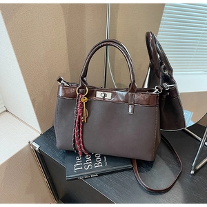 Deep brown matte leather tote bag with glossy trim and silver twist lock detail