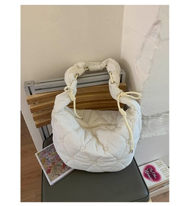 Détail du sac matelassé blanc avec motifs cœurs et poignée à cordon ajustable