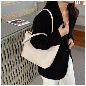 Close-up of cream pebble grain leather tote bag with elegant long shoulder straps