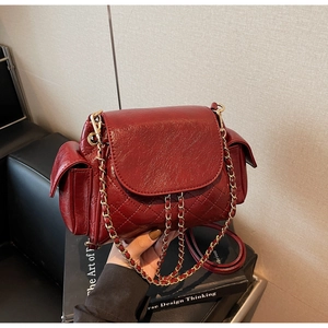 Détail du sac à bandoulière matelassé bordeaux avec fini brillant et chaîne dorée