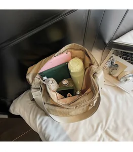 Spacious interior of khaki nylon tote bag showing storage for laptop and books
