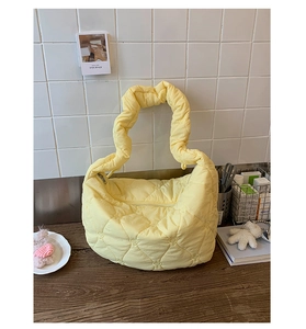 Détail du sac matelassé jaune clair avec broderie cœur et bandoulière à volants