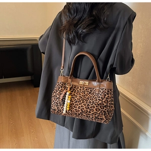 Dettaglio della borsa scamosciata leopardata con chiusura a scatto dorata e ciondolo a sfere