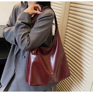 Détail du grand sac cabas bordeaux porté à l'épaule pour un style décontracté chic