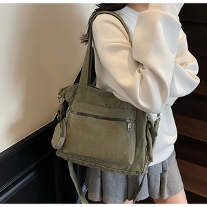 Detail view of the olive green canvas tote bag with multi-pocket design and small coin purse