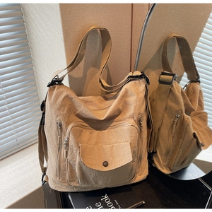 Detail of khaki nylon crossbody bag showing side brand label and stylish texture
