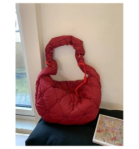 Détail du sac hobo matelassé bordeaux avec motifs de cœur et cordon de serrage orange