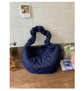 Détail du sac bandoulière matelassé bleu marine avec motifs de cœur et anse froncée