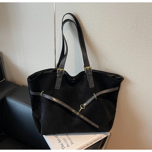 Close-up of black matte tote bag with retro gold hardware and suede texture