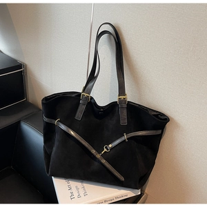 Detailed view of black matte tote bag with adjustable straps and metal hardware