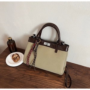 Detail of contrasting matte beige texture and brown leather strap with metal lock