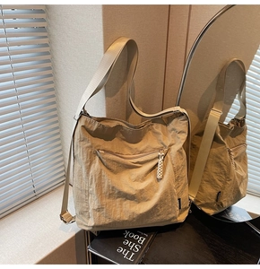 Detail of beige large capacity shoulder bag with pleated texture and wide strap