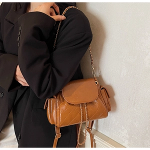 Détail du mini sac à dos matelassé marron avec chaîne dorée et poches latérales