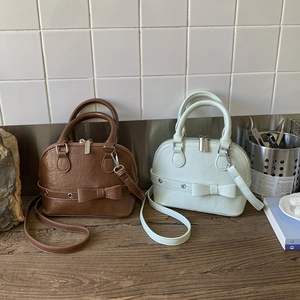 Detail of vintage mini shell bags with chic bow accents and lychee textured faux leather
