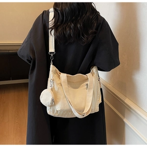 Rear view of a beige canvas tote bag with small coin purse shown on a model