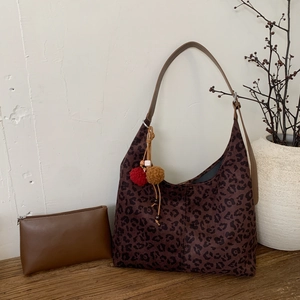 Vue détaillée du sac cabas vintage léopard en daim avec des breloques colorées et pochette