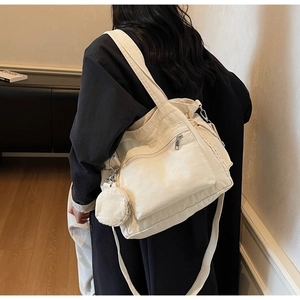 Detail of beige canvas tote with side coin purse and adjustable wide shoulder strap
