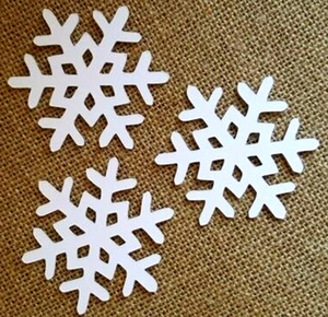 Three white laser-cut snowflake paper cards on brown burlap background for Christmas decor