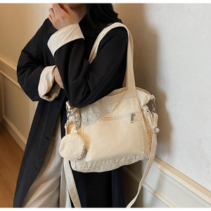 Detail of canvas tote bag with front zipper pocket and matching round coin purse accessory