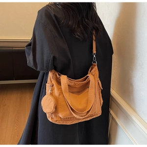 Detailed view of an orange canvas tote bag with side pockets and a small round coin purse