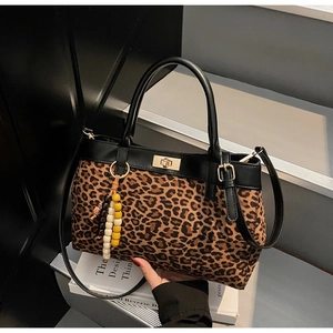 Dettaglio borsa leopardata con nappa in legno e chiusura a girello in metallo oro